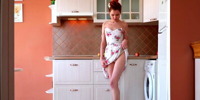 Redheaded babe Aphrodesia gently fucks her cunt in the kitchen